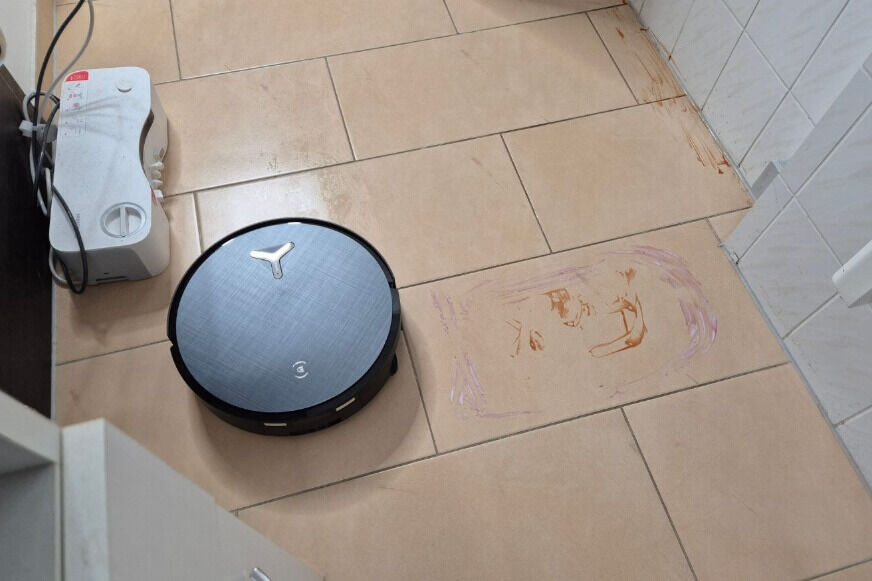 ECOVACS X12 OMNICYCLONE sprüht aus zwei Düsen Wasser auf einen eingetrockneten Ketchupfleck